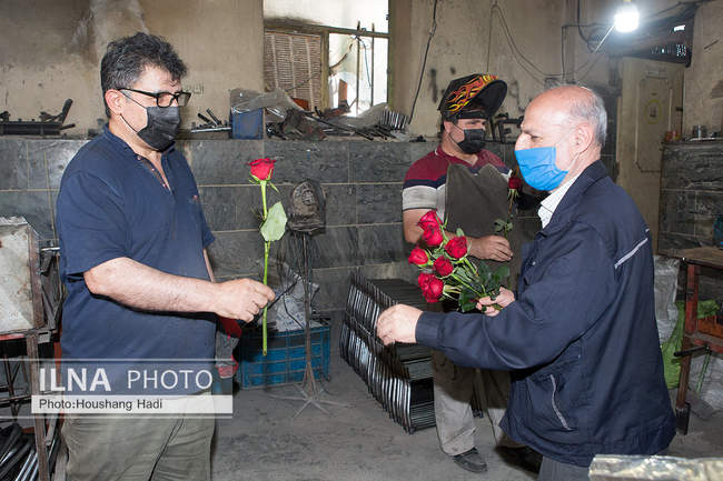 تقدیم شاخه گل در روز کارگر به کارگران معلول